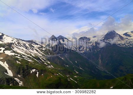 View Of Snowy Mountain Taur Mountains On The Background Of Blue Sky With Clouds