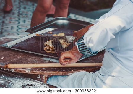 Turkish Woman Prepares Gozleme - Traditional Dish In The Form Of Flatbread Stuffed With Greens And C
