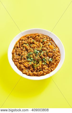 Keema Curry In Bowl Over Yellow Background With Copy Space. Indian And Pakistani Style Dish.