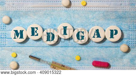 Medigap, Text On White Paper On Blue Background. Medical Concept.