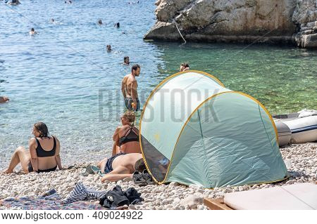 Vis, Croatia - Aug 17, 2020: Tourists Sunbathing On Sheltered Cove Stiniva Beach In Summer