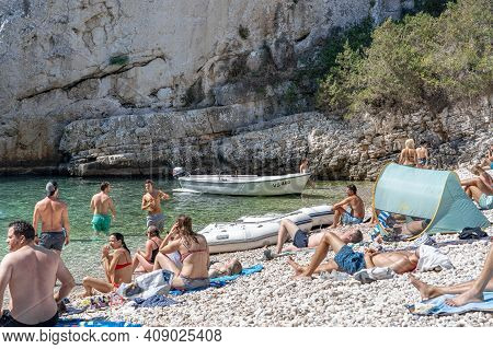 Vis, Croatia - Aug 17, 2020: Tourists Sunbathing On Sheltered Cove Stiniva Beach In Summer
