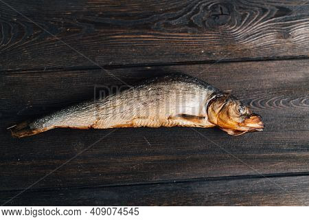 Dried Fish Lies On A Wooden Table Top View Texture