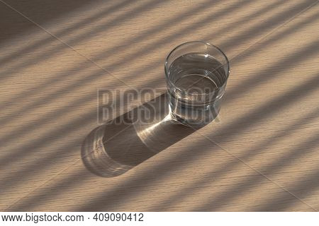 A Round Glass Of Clean Clear Drinking Water On A Table With Wonderful Shadows And Refraction Pattern