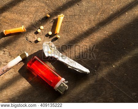 Narcotic Recreational Drugs Concept. Amphetamine,orange Straw,cigarette Lighter,freud Paper On Wood 