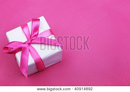 Geschenkbox mit Rosa Schleife auf rosa Hintergrund