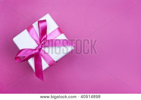 Geschenkbox mit Rosa Schleife auf rosa Hintergrund