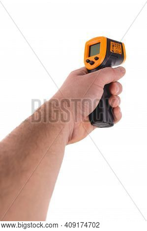 A Man Holds A Yellow-black Pyrometer. A Device For Non-contact Temperature Measurement. Studio Photo