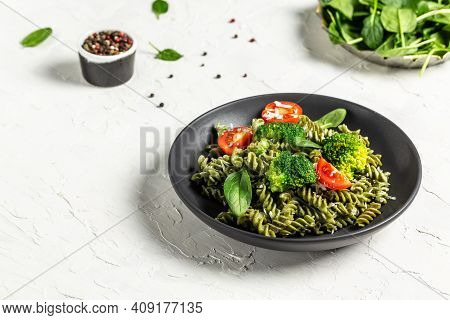 Penne Pasta With Broccoli, Avocado Sauce, Spinach Leaves And Cherry Tomatoes On Liht Background. Veg