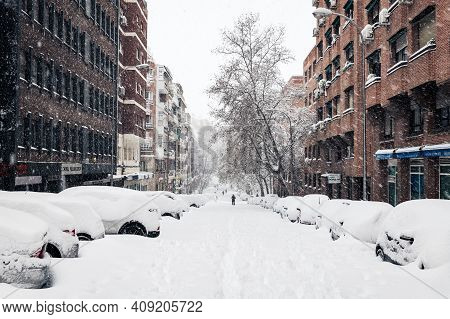 Madrid - January 9, 2021: Cars Covered Under The Snow Along A Commercial Street In Madrid During The