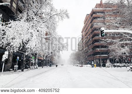 Madrid - January 9, 2021: Small Groups Of People Walk In The Snow Along A Commercial Street In Madri