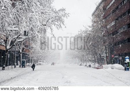 Madrid - January 9, 2021: Small Groups Of People Walk In The Snow Along A Commercial Street In Madri