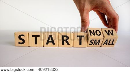 Start Small And Now Symbol. Businessman Turns Wooden Cubes And Changes Words 'start Small' To 'start