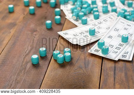 Many Barrels With Numbers And Cards For Lotto Or Russian Bingo Table Game On Wooden Surface. Russian