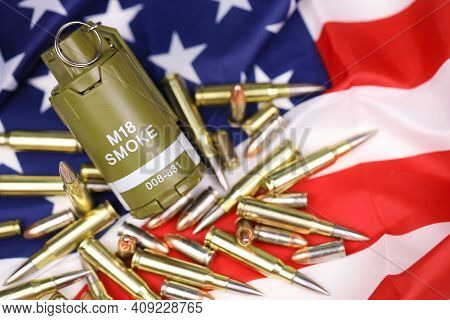M18 Smoke Grenade And Many Yellow Bullets And Cartridges On United States Flag. Concept Of Gun Traff
