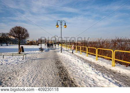 Tczew, Poland - February 21, 2021: Vistula Riverbank Promenade In Tczew. The Historic Bridge In Back