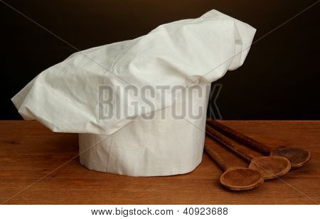 Chef's hat med skedar på brun bakgrund