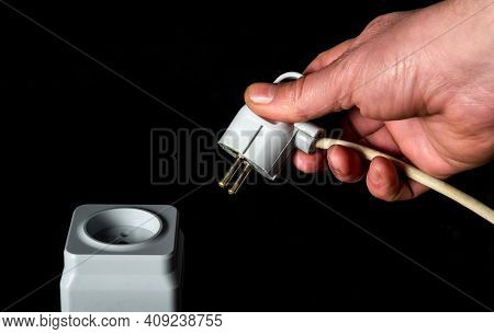 Manually Plug The Power Cord Into A White Plastic Or European Power Outlet. Closeup Of A Man Hand In