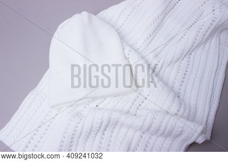 White Set Of Warm Hat And A Scarf On A Grey Background. Accesoires For Autumn And Winter. Perfect Wh