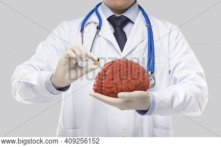 Doctor Holding Brain And Tonic In Gray Background