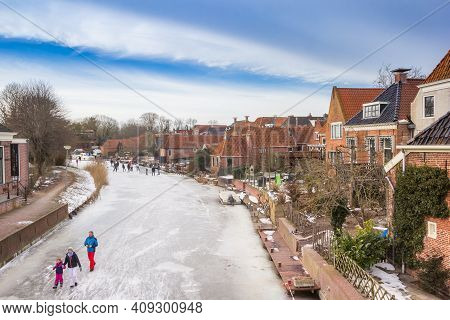 Winsum, Netherlands - February 14, 2021: Frozen Canal In The Center Of Historical Village Winsum, Ne