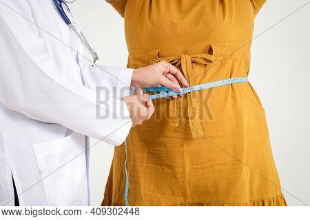 Female Doctor Wearing White Uniform Hold A Tape Measure Around The Waist Of A Obese Woman Wearing A 