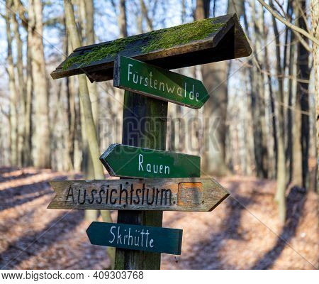 Rauen, Brandenburg, Germany - February 21, 2021 Sign In The Forest - Shows The Direction To Rauen, T
