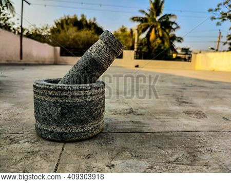Picture Of Traditional Stone Mortar And Pestle On Blur Background.