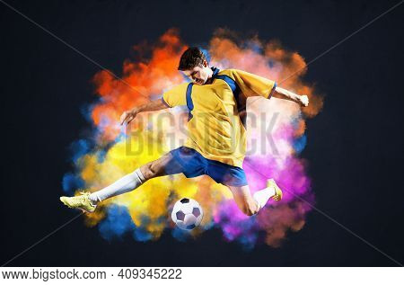 Soccer Player Kicking Ball In Colorful Smoke. Sportsman In Yellow And Blue Uniform In Action. Soccer