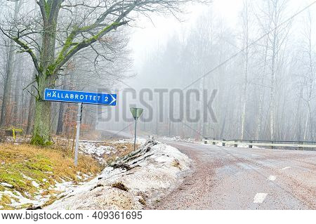 Road Crossing With Sign Showing The Way To Hallabrottet 2 Kilometers