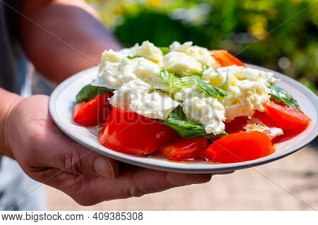 Waiter In Cafe Holding In Hands Fresh Vegetarian Caprese Salad Made From Buffalo Mozzarella Cheese, 