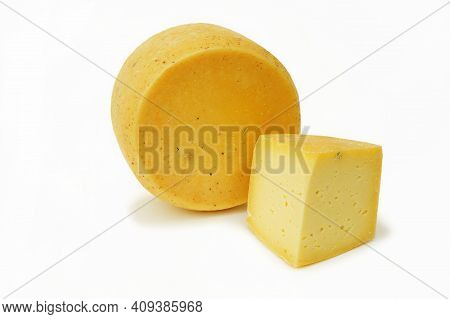 Round Head Of Hard Cheese With A Small Slice On An Isolated White Background Close-up. Homemade Chee