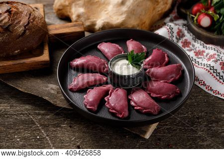 Delicious Traditional Russian Dumplings, Handmade Dough Painted With Beets. Still Life On A Wooden B