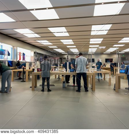 Apple Employees Waiting On Customers With Plexiglass Sheilds Between While Wearing Face Masks Due To