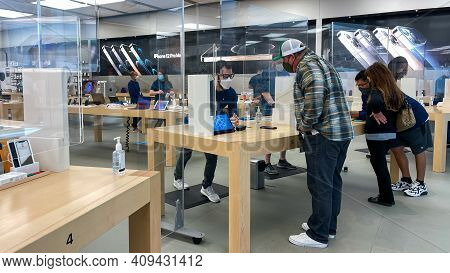 Apple Employees Waiting On Customers With Plexiglass Sheilds Between While Wearing Face Masks Due To