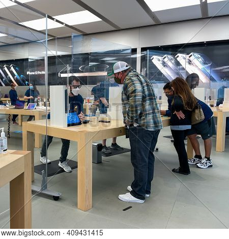 Apple Employees Waiting On Customers With Plexiglass Sheilds Between While Wearing Face Masks Due To