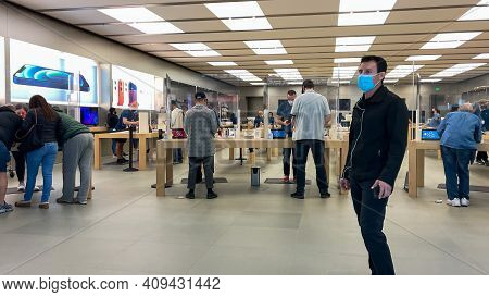Apple Employees Waiting On Customers With Plexiglass Sheilds Between While Wearing Face Masks Due To