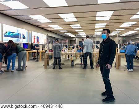 Apple Employees Waiting On Customers With Plexiglass Sheilds Between While Wearing Face Masks Due To