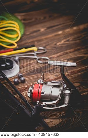 Fishing Tackle On A Wooden Background. Studio Photo With Vignetting.