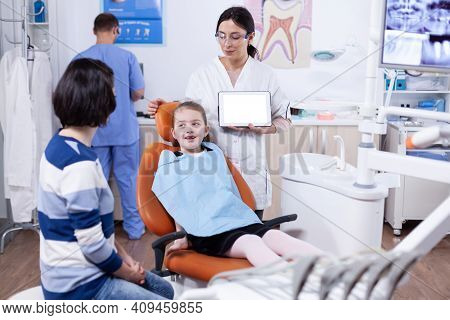 Dentist In Clinic With Chroma Key On Tablet Pc Display Consulting Kid With Bad Tooth. Stomatolog Exp