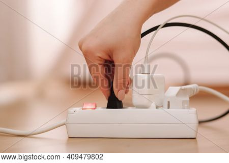 Woman Pluging The Wire Into White Extension Cord. Close Up Of Female Hand Put Cabel