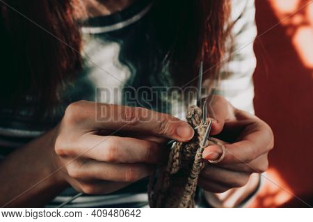 Female Hands Knitting With Beige Wool. Close-up Of Woman Knits Scarf, Sweater, Socks Or Mittens. Fan