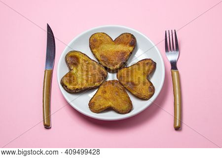 Heart-shaped Fried Potatoes. Fried Potatoes In A White Plate On A Pink Background. Love Of Food