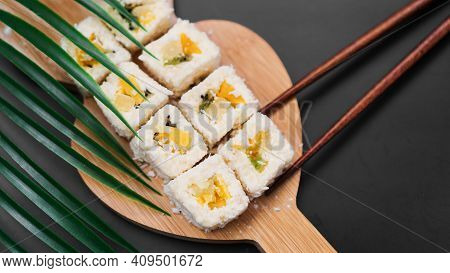 Dessert Sushi. Sweet Kiwi, Pineapple Sushi Rolls. Sushi On A Wooden Tray On A Black Background. Hold