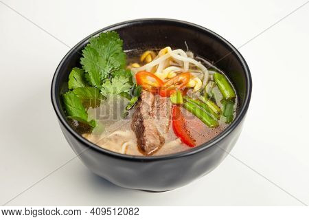 Asian Soup With Beef And Udon Noodles In A Black Karelian. Ingredients Broth, Beef, Bell Pepper, Udo