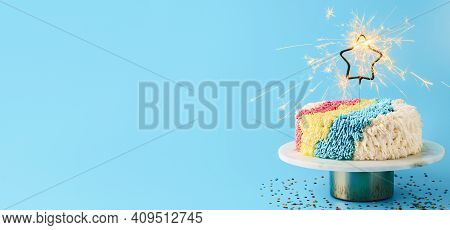 Shag Cake With Burned Sparkler Star On Blue Background. Colorful Shag Cake With Perfect Vanilla Butt