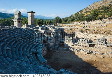 Ruins of amphitheater and Rock tombs in Xanthos Ancient City, Turkey. Sunny day, Old Lycian civilization heritage architecture