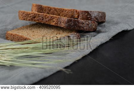 Slices Of Brown Bread With Wheat On A Gray Tablelcoth
