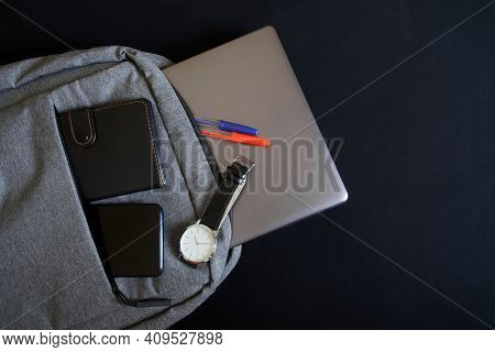 A Small Urban Gray Textile Backpack With A Laptop Or Ultrabook, A Wallet, A Smartphone And A Wristwa
