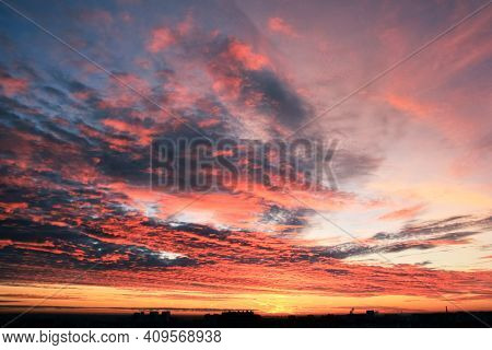 Beautiful Sunrise In The Clouds Over A Big City. Orange-red Tones, Multi-layered Light Clouds, The S